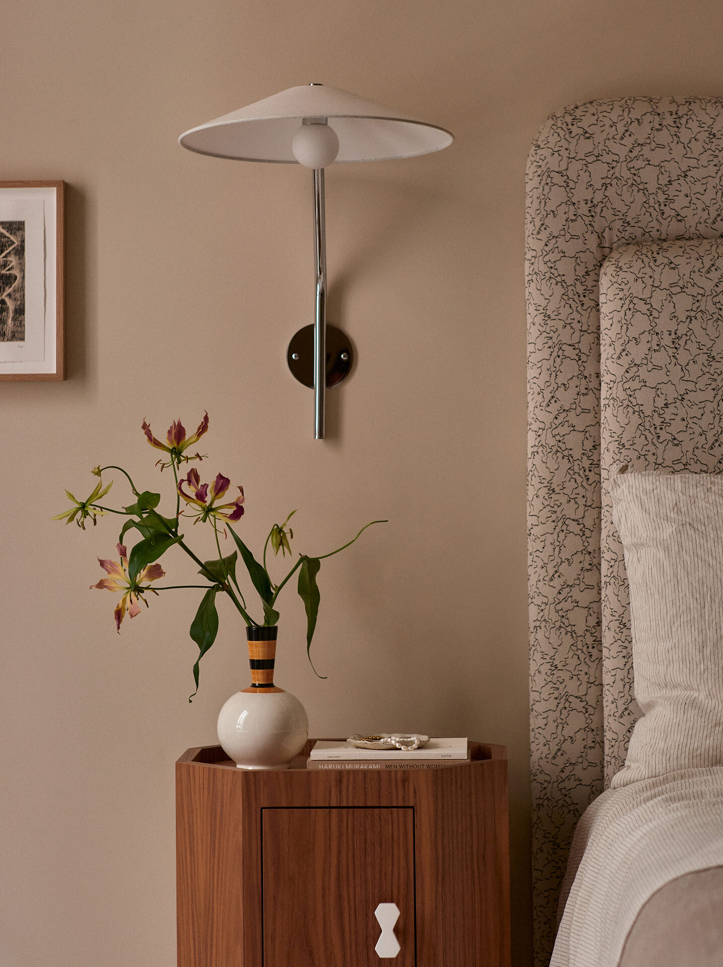 Bedside detail with flowers and walnut nightstand
